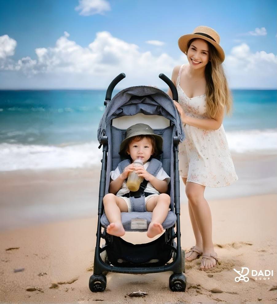 Mama z dzieckiem w lekkiej spacerówce podczas rodzinnego wypoczynku nad morzem.